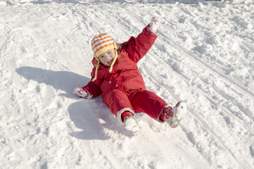 Fototapeta na wymiar Little girl playing outdoors in snow