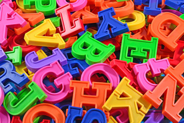 Heap of plastic colored alphabet letters close up
