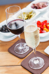 Two Glasses of Sparkling Wine and Red Wine on a wooden table.