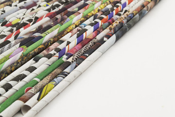 Straws of colored newsprint with letters
