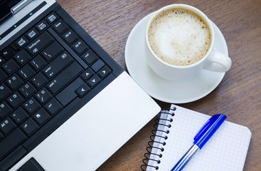 Office objects with laptop, coffee cup and a notebook