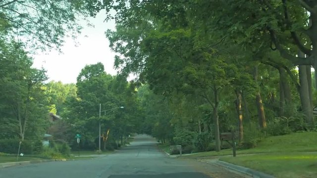 Driving plate: left side (passenger view), upscale 1950s-era homes in an affluent Mid West US neighborhood.  Intended for compositing.  24mm lens, stabilized clip, moderate speed, recorded in 4K, UHD.