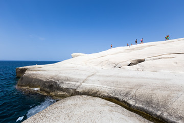 Tourists enjoy the clear water of Sarakiniko beach in Milos, Gre