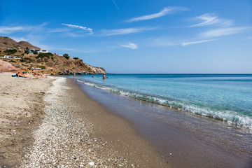 Obraz premium Tourists enjoy the clear water of the beautiful beach in Milos i