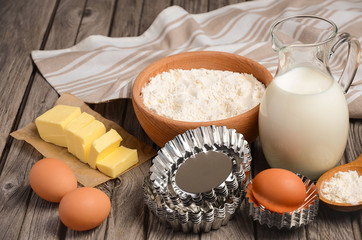Ingredients for baking - milk, butter, eggs and flour. Rustic background. Horizontal permission. Selective focus.
