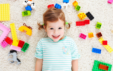 happy child laughing and playing with toys constructor