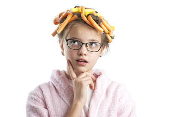 Thoughtful girl in hair curlers is looking up..