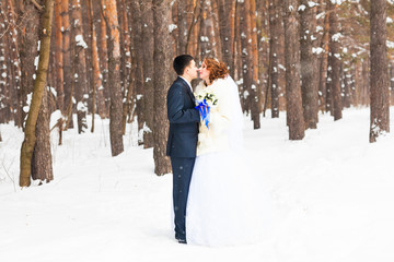 Naklejka premium bride and groom kissing in the winter woods