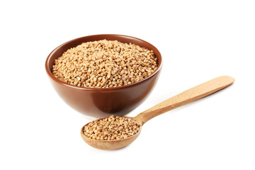 Buckwheat seeds in wooden spoon and bowl on a white background