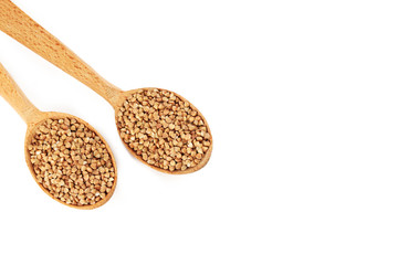 Buckwheat seeds in wooden spoon on a white background
