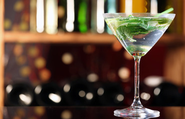 Glass of cocktail on bar background