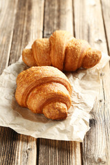 Tasty croissants on brown wooden background