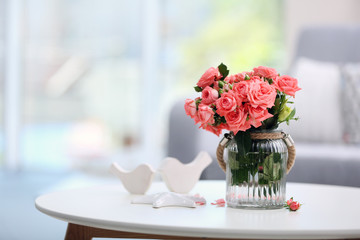 Beautiful rose in vase on table in room