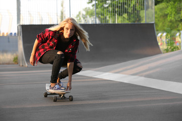 Young woman with skating board on the road