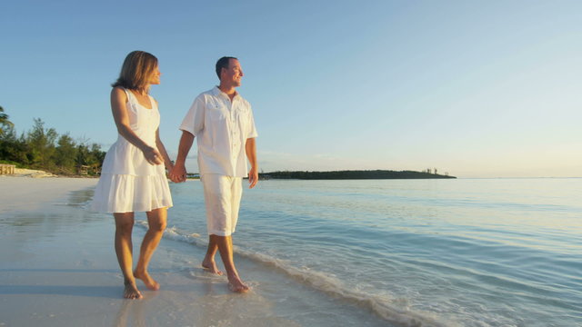 Caucasian couple barefoot on a beach together 