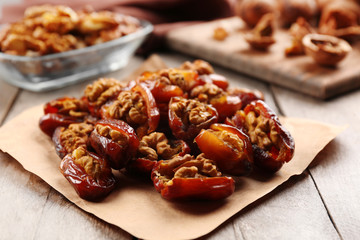 Walnut and date fruit on wooden table, close-up