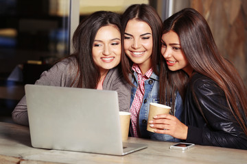 Best friends with laptop together sitting at cafes terrace