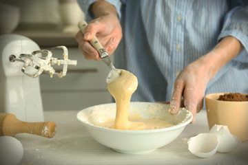 Woman is mixing dough with a spoon