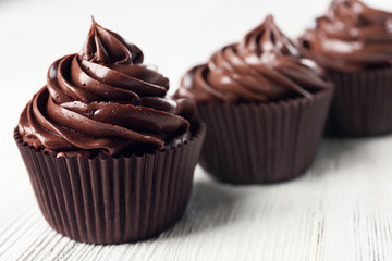 Chocolate cupcakes on light wooden background