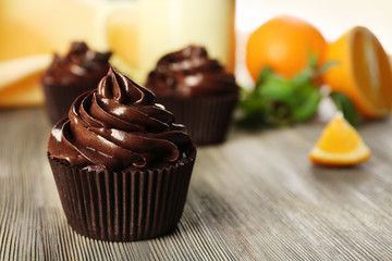 Chocolate cupcakes served with orange on a table