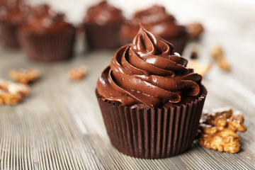 Chocolate cupcakes with nuts on wooden table