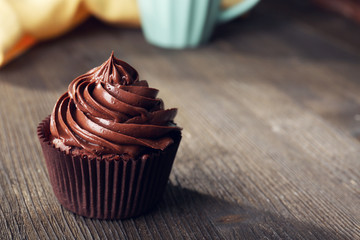 Chocolate cupcake served with a drink on wooden table