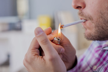 Close up of Man smoking cigarette. Man lighting the cigarette.