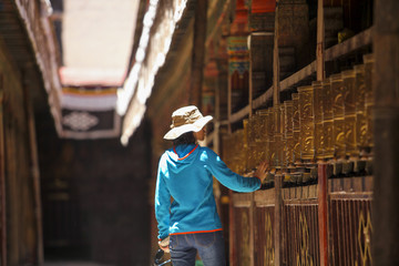 Tourist touching prayer wheel in Jokhang Temple