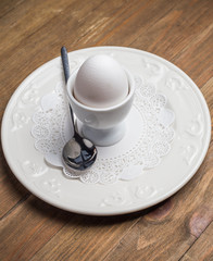Breakfast with soft-boiled egg, over old wooden table. 