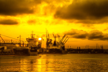 Fototapeta premium Silhouettes of cranes and ships in port of Gdansk, Poland.