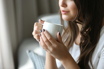Portrait of pretty young woman with cup of coffee, close up