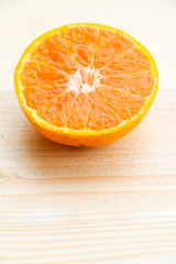 Organic orange fruit. Slices on soft wooden background