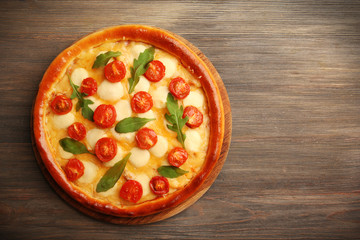 Pizza Margherita with arugula on wooden background