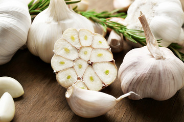 Composition of garlic and rosemary on wooden background, close up