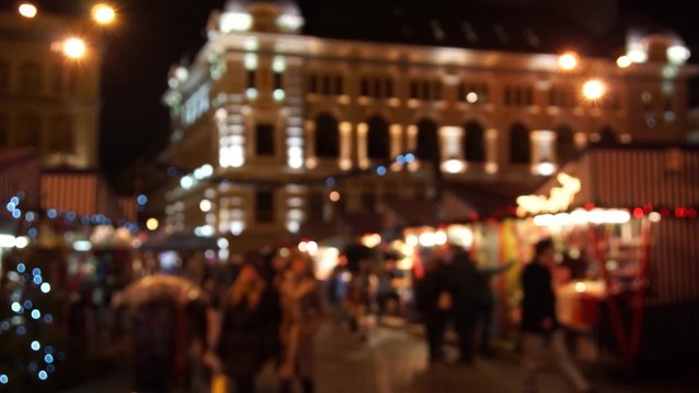 People visit Christmas Fair in old town at evening in Riga, Latvia. Blurred