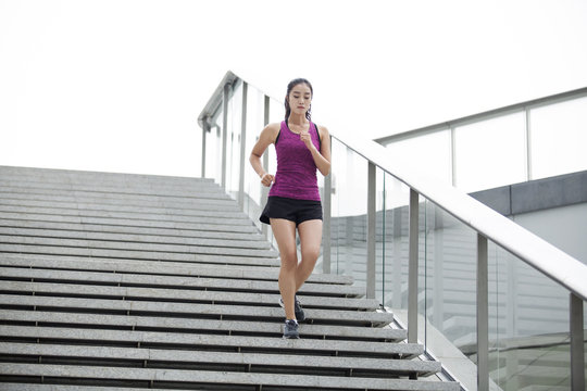 Young woman running down stairs for exercise