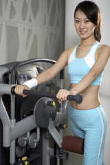 Fototapeta premium Young Woman On An Exercise Machine At The Gym