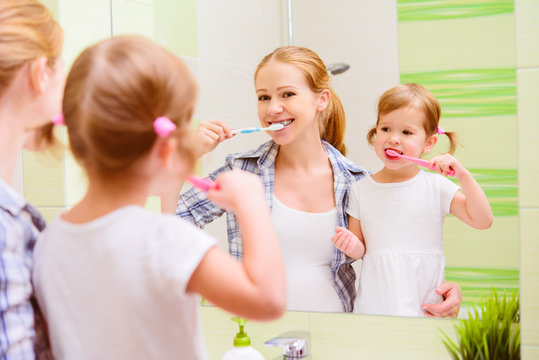 Happy Family Mother And Daughter Child Brushing Her Teeth Toothb