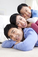 Fototapeta premium Young Chinese family lying on the floor close-up