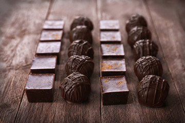 Delicious chocolate candies on wooden background