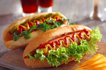 Delicious hot-dog with chips on wooden background