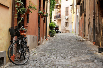 Fototapeta na wymiar Italy, street with bicycle and flowers in Rome