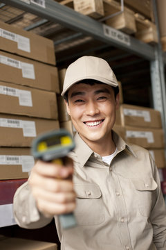 Male Chinese warehouse worker with scanner