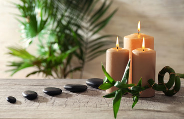 Spa composition of candles, stones and bamboo on light background