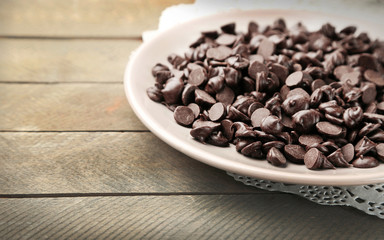 Chocolate morsels on wooden background