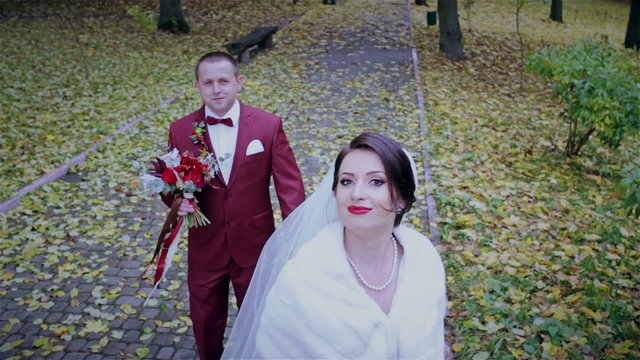 Happy bride and groom in yellow autumn foliage 
