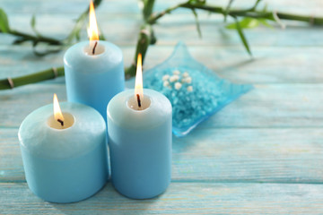 Obraz na płótnie Canvas Blue candles with spa salt and bamboo on table