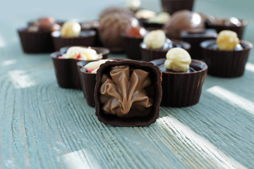 Assorted chocolate candies on wooden background, close up