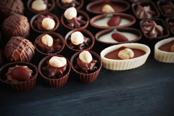 Delicious chocolate candies on blue wooden background, close up