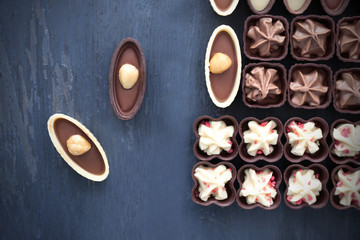 Delicious chocolate candies on blue wooden background